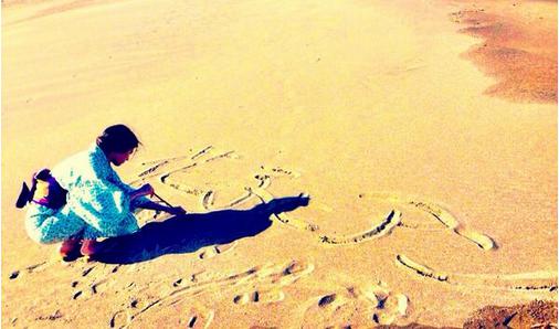 浜辺で文字を書く、吉高由里子。（画像は『twitter.com/ystk_yrk』のスクリーンショット）