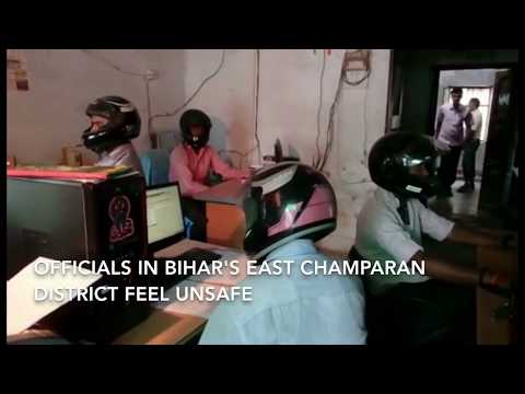 ヘルメットを被り仕事する職員たち（画像は『Hindustan Times　2017年7月15日公開 YouTube「Officials in Bihar are using helmets in their office」』のサムネイル）