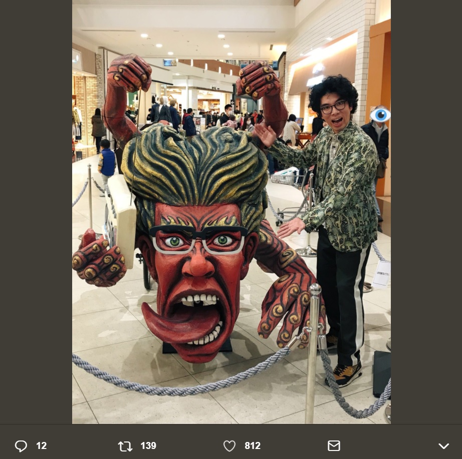 片桐仁と『ギリ展』の作品（画像は『片桐仁なう　2018年3月21日付Twitter「本日、イオンモール春日部で開催された『5周年ロゴ』お披露目トークショー、行ってきましたー！」』のスクリーンショット）