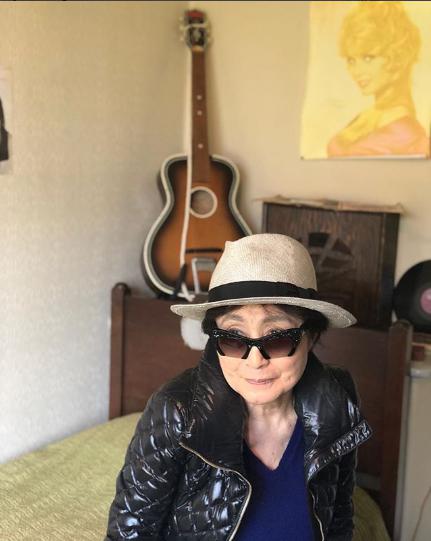 ジョン・レノンの部屋に座るオノ・ヨーコ（画像は『Yoko Ono　2018年5月18日付Instagram「This is John’s room in Menlove Avenue.」』のスクリーンショット）