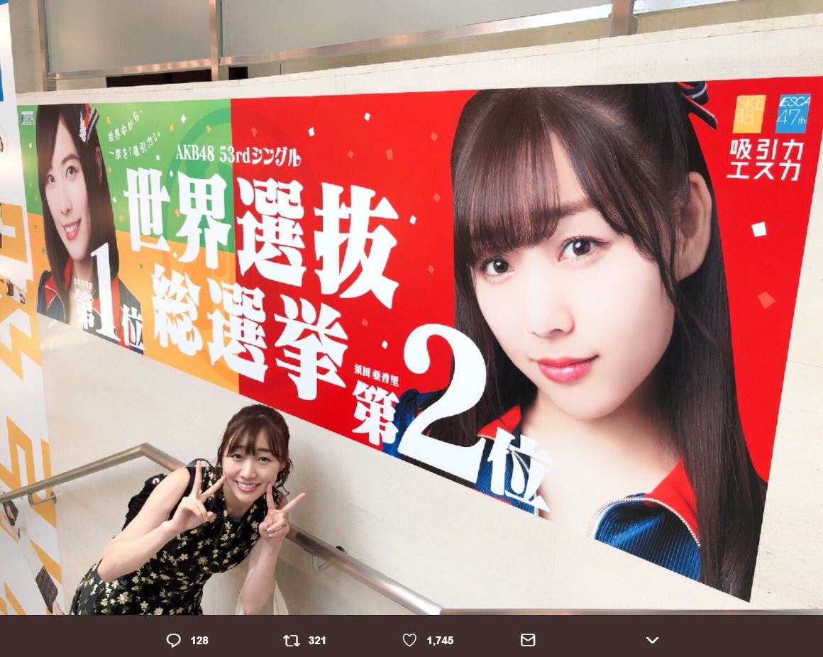 巨大ポスターの前でピースサインする須田亜香里（画像は『須田亜香里（SKE48）　2018年7月1日付Twitter「＃エスカ さんありがとうございます」』のスクリーンショット）