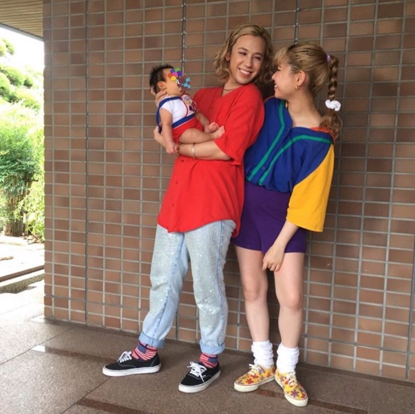 長男を抱くりゅうちぇるとぺこ（画像は『Peco Okuhira Tetsuko　2018年9月1日付Instagram「“90年代のドラマに出てくる、旦那さんとベイビーといっしょにフットボール観戦に行く子” がテーマ」』のスクリーンショット）