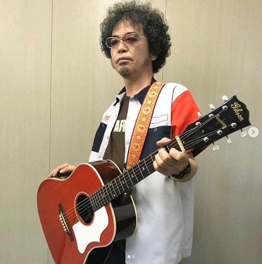 ギターを肩から下げた奥田民生（画像は『RCMR　2019年9月2日付Instagram「【OT25th記念グッズ第2弾】﻿」』のスクリーンショット）