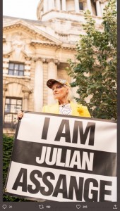 「私はジュリアン・アサンジ」の横断幕を掲げるヴィヴィアン・ウエストウッド（画像は『Vivienne Westwood　2020年7月21日付Twitter「“I am Julian Assange, I am the canary in the cage.” - Vivienne Westwood」』のスクリーンショット）