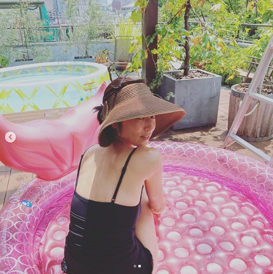 プールに座る高岡早紀（画像は『高岡早紀　2020年8月9日付Instagram「午前中に家事を全て終わらせて、白ワイン片手にプールで遊ぶ～」』のスクリーンショット）