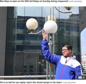 街灯にも手が届いてしまう（画像は『The Sun　2020年10月20日付「NEW HEIGHTS This is the 14-year-old Chinese boy who measures well over 7 feet tall and is set to become the tallest male teenager」（Credit: Newsflash）』のスクリーンショット）