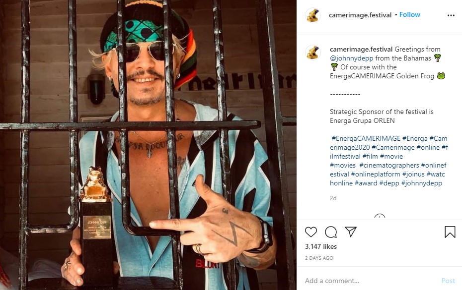 牢獄のような部屋からトロフィーを受けとるジョニー（画像は『EnergaCAMERIMAGE　2020年11月22日付Instagram「Greetings from ＠johnnydepp from the Bahamas」』のスクリーンショット）