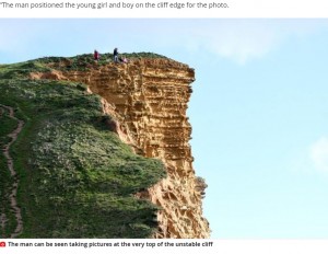 高さ45メートル超の崖の上で写真を撮る男性（画像は『Mirror　2020年12月13日付「Chilling snaps at edge of cliff as man ignores safety notices to photograph kids」』のスクリーンショット）