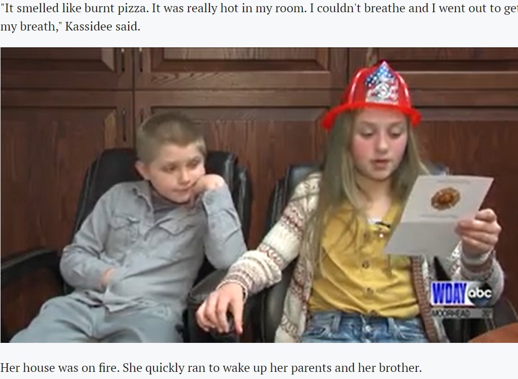 消防隊から贈られたヘルメットをかぶり、カードを読むキャシディちゃんと弟（画像は『INFORUM　2021年1月28日付「10-year-old girl, kitten save Pembina County family from burning homes」』のスクリーンショット）