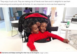 ホスピスでお茶を待つ2人（画像は『WalesOnline　2021年3月2日付「The extraordinary story of conjoined twins expected to die within days of being born who are now settling in school and learning to walk」（Image: Ibrahima Ndiaye）』のスクリーンショット）