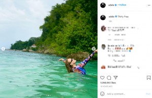 鮮やかな水着を着て海の中で両手を挙げるアデル（画像は『Adele　2021年5月5日付Instagram「Thirty Free」』のスクリーンショット）