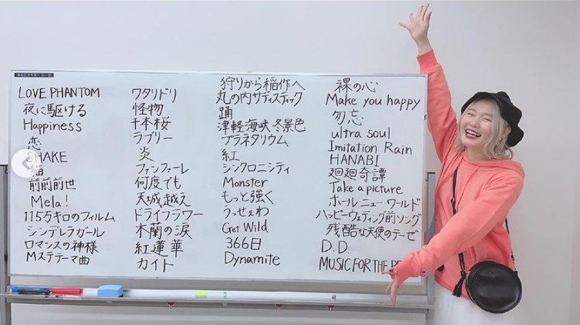 視聴者リクエストを書いたホワイトボードの横で微笑むハラミちゃん（画像は『ハラミちゃん　2021年5月23日付Instagram「＃Mステ おふしょ」』のスクリーンショット）
