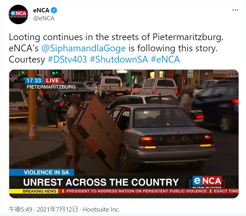 大画面テレビを車に積み込もうとする男（画像は『eNCA　2021年7月12日付Twitter「Looting continues in the streets of Pietermaritzburg.」』のスクリーンショット）