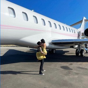 飛行機の前でキスするトラヴィスとコートニー（画像は『travisbarker　2021年8月18日付Instagram「With you anything is possible ＠kourtneykardash」』のスクリーンショット）