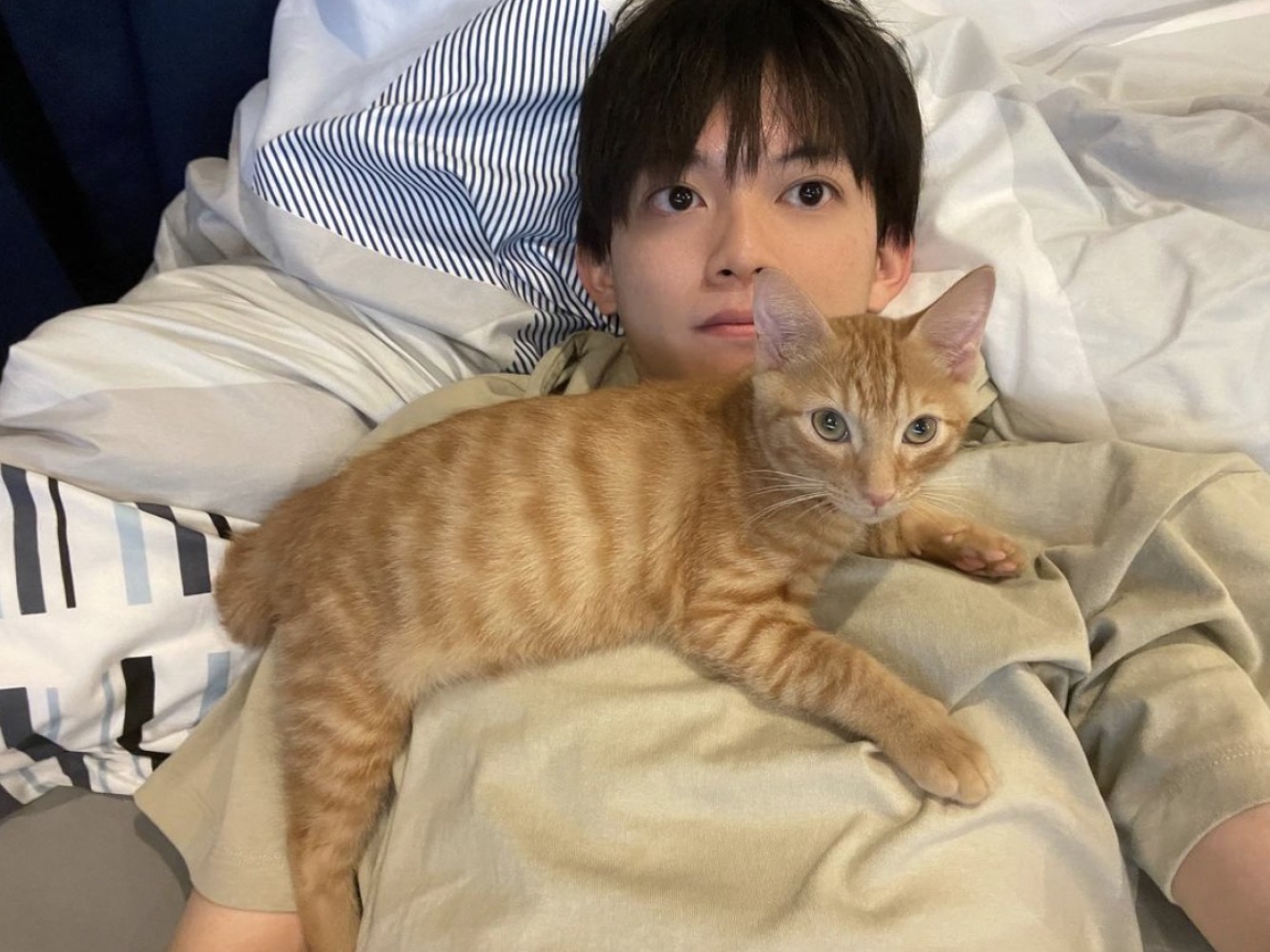 7月から飼い始めた保護猫“リド”くんと松丸亮吾（画像は『松丸 亮吾　2021年8月4日付Instagram「起きたら猫のベッドになってたので遅刻します。」』のスクリーンショット）