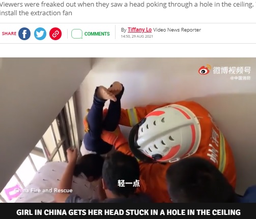 逆さまのまま脚を支えてもらう女児（画像は『The Daily Star　2021年8月29日付「Girl gets head stuck in ceiling like horror movie in hilarious freak accident」（Image: Weibo/China Fire Brigade）』のスクリーンショット）