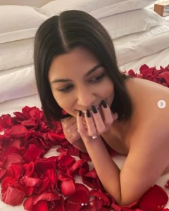 バラを敷き詰めたベッドに横たわるコートニー（画像は『Kourtney Kardashian　2021年10月24日付Instagram「I can’t believe this was a week ago ＠travisbarker」』のスクリーンショット）