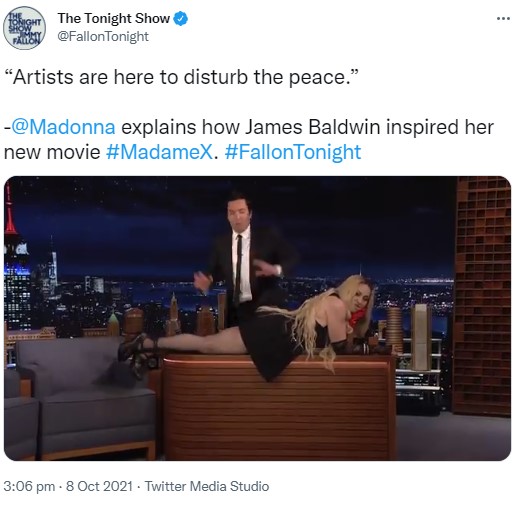 デスクに堂々と横たわるマドンナと困惑するジミー・ファロン（画像は『The Tonight Show　2021年10月8日付Twitter「“Artists are here to disturb the peace.”」』のスクリーンショット）