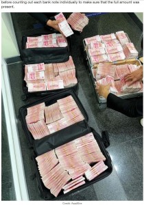 スーツケースにすべての現金を詰め込んだサンウェアさん（画像は『LADbible　2021年10月21日付「Chinese Millionaire Withdraws Huge Sum And Makes Bank Staff Count It Out」（Credit: AsiaWire）』のスクリーンショット）