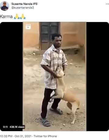 犬の首を持ち押さえつける男（画像は『Susanta Nanda IFS　2021年10月31日付Twitter「Karma」』のスクリーンショット）