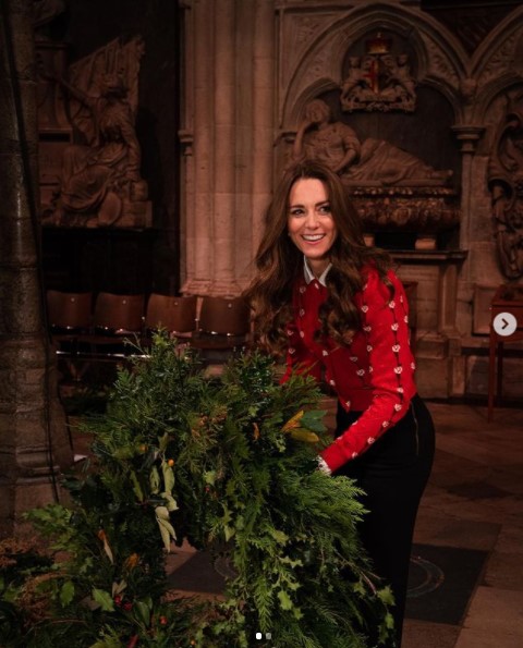 「ミュウミュウ」のカーディガンを着たキャサリン妃と巨大なクリスマスリース（画像は『Duke and Duchess of Cambridge　2021年12月22日付Instagram「I’m so excited to be hosting Together at Christmas here at Westminster Abbey, a place that’s really special to William and me.」』のスクリーンショット）