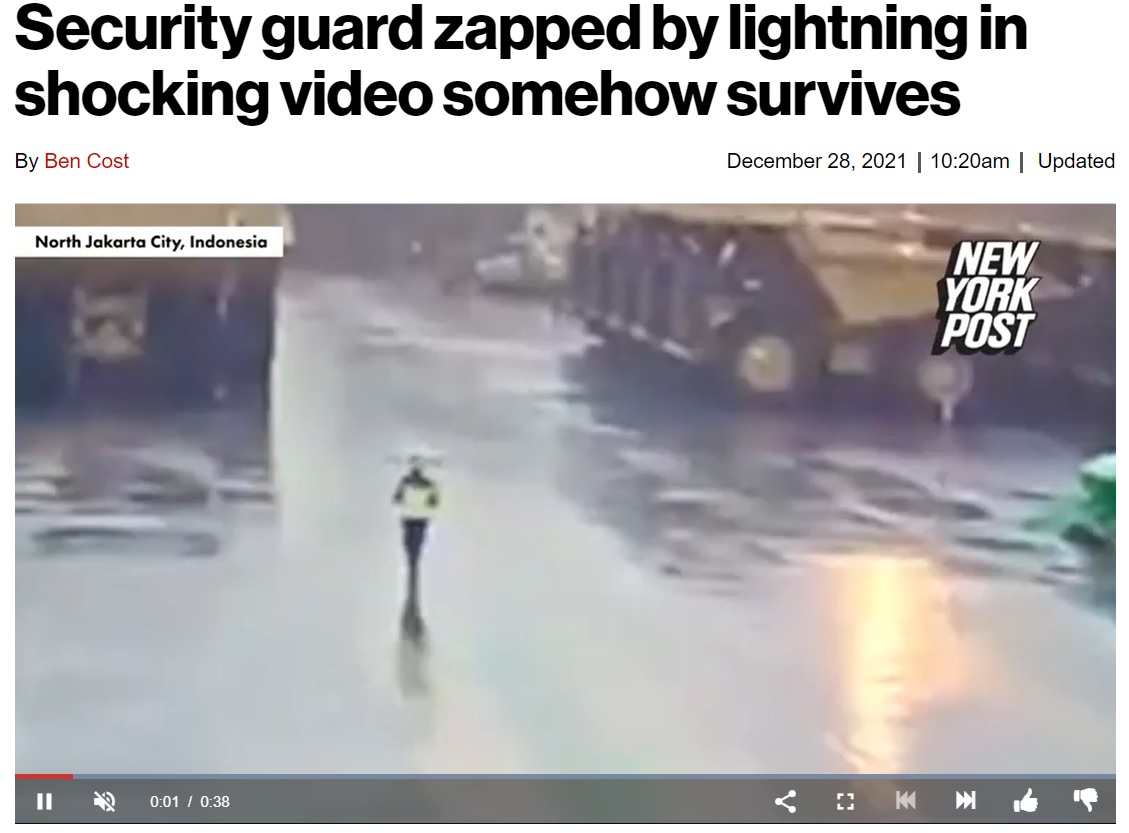雨の中、傘をさして歩いていた警備員（画像は『New York Post　2021年12月28日付「Security guard zapped by lightning in shocking video somehow survives」』のスクリーンショット）
