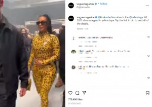 全身に粘着テープを巻いて歩くキム（画像は『Vogue　2022年3月6日付Instagram「＠kimkardashian attends the ＠balenciaga fall 2022 show wrapped in yellow tape.」』のスクリーンショット）