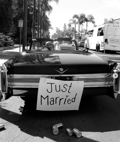 「Just Married」のサインを掲げた車でキスを交わす2人（画像は『Kourtney　2022年5月16日付Instagram「Till death do us part.」』のスクリーンショット）