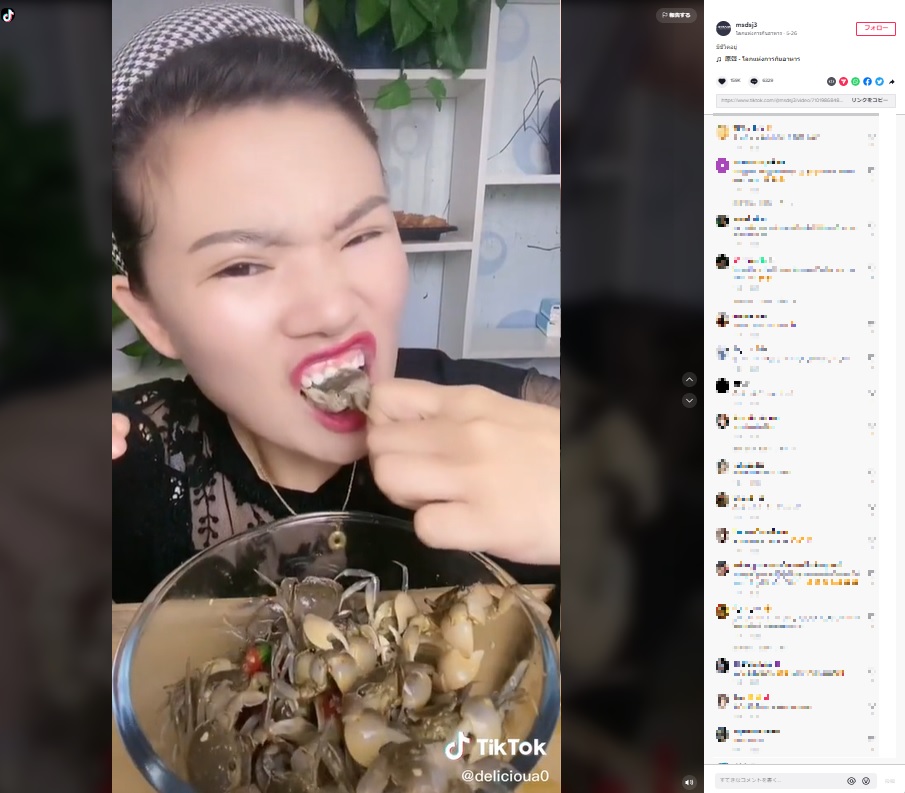 カニを噛みちぎる女性（画像は『โลกแห่งการกินอาหาร　2022年5月26日付TikTok「มีชีวิตอยู่」』のスクリーンショット）