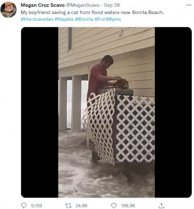 室外機の上に取り残された野良猫を救出するマイクさん（画像は『Megan Cruz Scavo　2022年9月28日付Twitter「My boyfriend saving a cat from flood waters near Bonita Beach.」』のスクリーンショット）