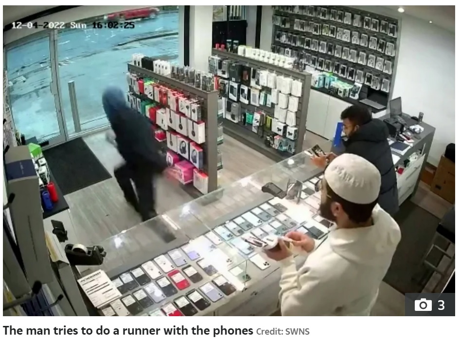 男は商品のスマホを2台持ったまま出口へ向かって走り出した（画像は『The Sun　2022年12月6日付「ESCAPE’S CUT OFF Moment bungling thief tries to flee shop with stolen phones ― but can’t open the DOOR」（Credit: SWNS）』のスクリーンショット）