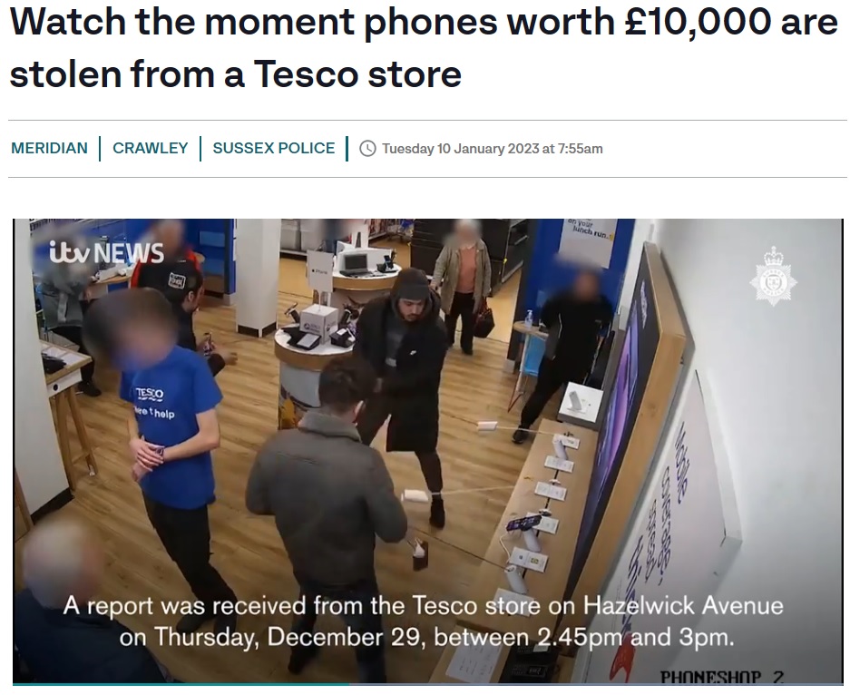 展示台からスマホを引きはがす男たち（画像は『ITVX　2023年1月10日付「Watch the moment phones worth ￡10,000 are stolen from a Tesco store」』のスクリーンショット）