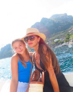 母ヴィクトリア・ベッカムと寄り添って並ぶハーパーちゃん。ヴィクトリアはサングラスと帽子で日焼け対策をしている（画像は『Victoria Beckham　2023年8月26日付Instagram「Family time is everything」』のスクリーンショット）