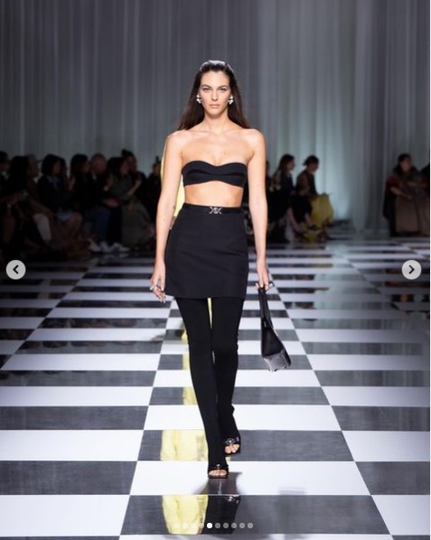 「ヴェルサーチェ」の2024年春夏ミラノ・コレクションに出演したヴィットリア・チェレッティ。上半身を露出した、全身黒のスタイルだ（画像は『Donatella Versace　2023年9月23日付Instagram「Fresh and graphic.」』のスクリーンショット）