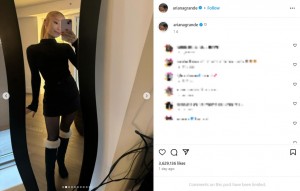 黒いミニドレスを着て自撮り写真を撮るアリアナ。白いファーが付いた黒いロングブーツを履いている（画像は『Ariana Grande　2023年12月22日付Instagram』のスクリーンショット）