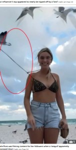 レレさんの背後では、カモメに引っ張られたビキニの紐がピンと伸びてしまっている（画像は『The Sun　2024年1月11日付「SQUAWK-WARD! Cheeky moment influencer Lele Pons nearly goes TOPLESS as hilarious vid ‘shows seagull untie her bikini’」（Credit: Jam Press Vid）』のスクリーンショット）