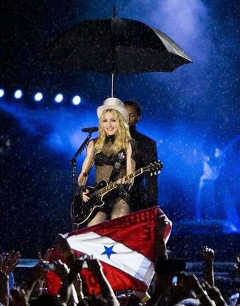 14日、黒傘付きのコンサートとなったブラジルでのマドンナ